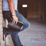Man propped against brick wall with Bible in hand