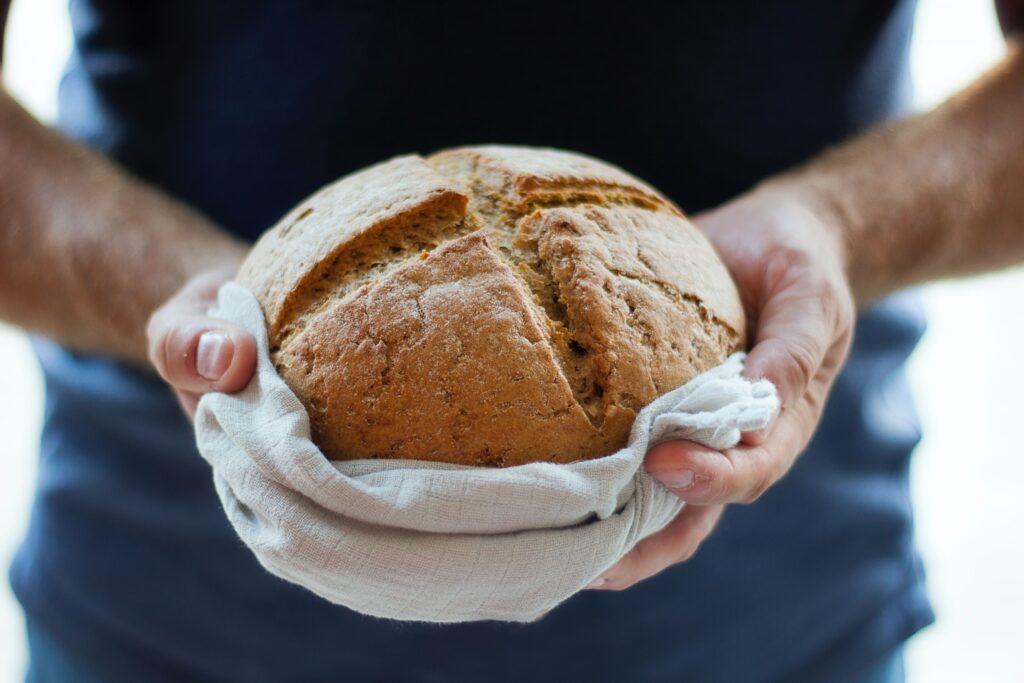 Hands holding loaf of bread