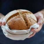 Hands holding loaf of bread