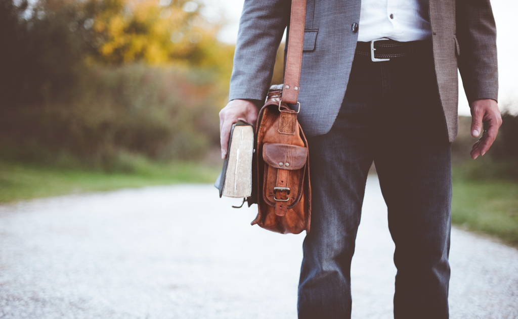 Stock image of man with bookbag and book